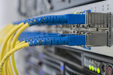 Communication equipment in the server room of the data center. Fiber-optic modular interfaces in close-up. Many fiber patch cords are connected to the interfaces of Central Internet router.