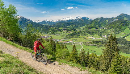 Obraz premium pretty senior woman riding her electric mountain bike on the Wallraff Trail in the Nebelhorn area above Oberstdorf, Allgau Alps, Bavaria, 