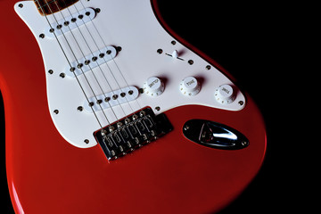 Red electric guitar isolated on a black background