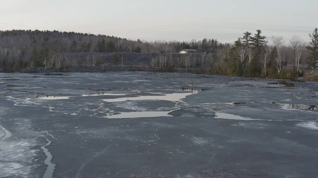 Melting ice fast descending aerial over Hebron Lake, Monson Maine 