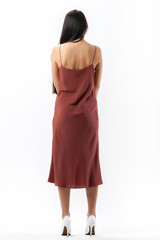 brunette posing in clothes for a catalog on a white background