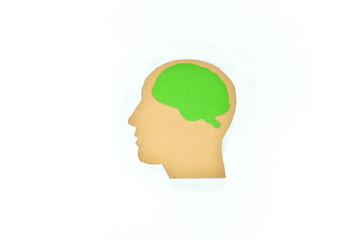 Mental health awareness and think green concept. Human head profile silhouette with green brain cardboard cutout.
