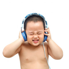 The little boy listens to music from the headphones. And with a very funny expression.