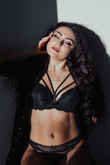 Fototapeta premium Beautiful fashionable brunette woman in black lingerie