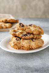 Chocolate chip cookies on linen napkin on gray table. Stacked chocolate chip cookies close up.