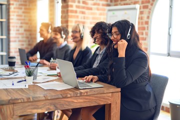 Group of call center workers smiling happy and confident. Working together with smile on face using headset at the office.