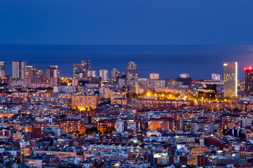 Fototapeta na wymiar Barcelona iluminada una noche de Primavera, con luna llena, la tranquilidad de la ciudad y la vista de los edificios de diagonal Mar