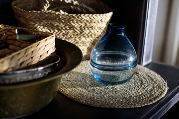 Blue round glass vase on the straw napkin