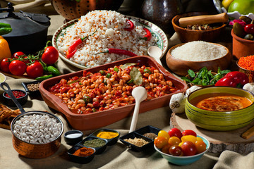 cooked and uncooked haricot beans, served with traditional cooked rice and Traditional red lentil soup. Table garnished with legumes, vegetables and seasonings. Rich cuisine, delicious food.