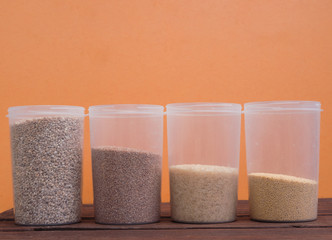 Various cereals in plastic containers. Raw porridge in a container on a wooden table.