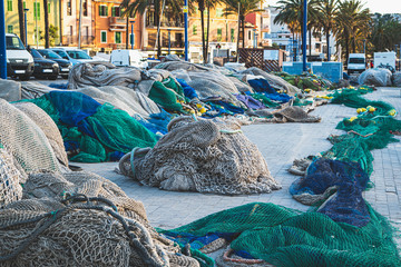 Fishing nets in port blue and green color not in use stacked together for renovation