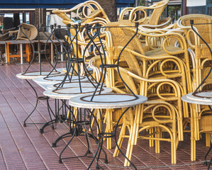 Chairs y tables collected chained together on a bar terrace waiting to use without clients