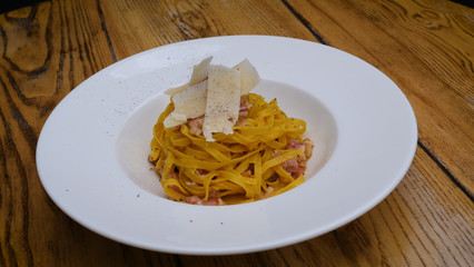 A dish of the Carbonara paste with seafood in a big white plate. Pasta, cafe.
