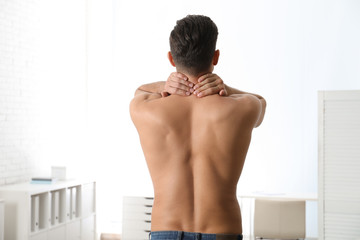 Man suffering from pain in neck at clinic. Visiting orthopedist