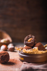 Homemade chocolate truffles  on wooden table closeup view. Tasty vegetarian candy or balls  with raw cocoa powder