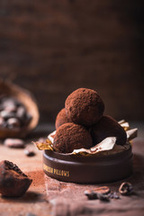 Homemade chocolate truffles  on wooden table closeup view. Tasty vegetarian candy or balls  with raw cocoa powder