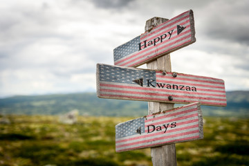 Happy kwanzaa days text on wooden american flag signpost outdoors in nature.