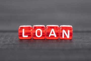 Word LOAN written on red cubes. Concept loan sizing, interest, fees banks.