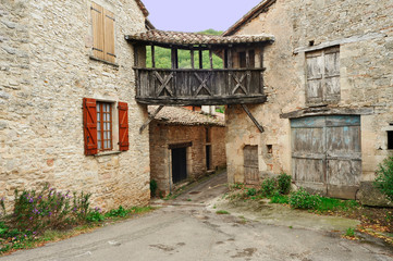 Fototapeta na wymiar Vieilles maisons de village reliées par une passerelle en bois en Occitanie, France