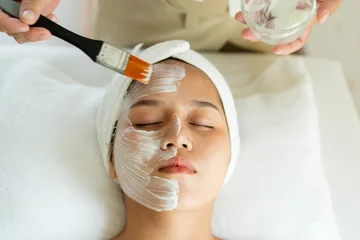 Fototapete Spa Schöne junge asiatische Frau, die Gesichtspflege von Kosmetikerin im Spa-Salon bekommt, Gesichtspeeling-Maske, Spa-Schönheitsbehandlung, Hautpflegekonzept