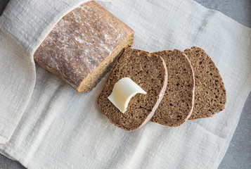 homemade black rye bread is cut into pieces on a light linen napkin