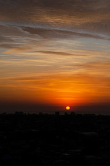 sunrise over the sea with city silhouette.