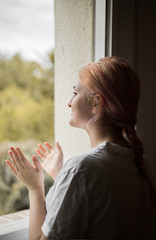 Girl clapping at the window of her bedroom