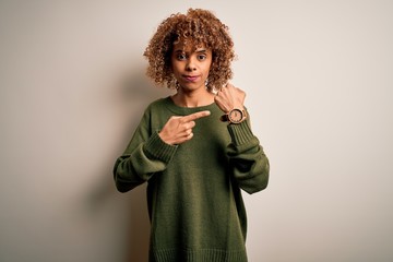 Beautiful african american woman with curly hair wearing casual sweater over white background In...