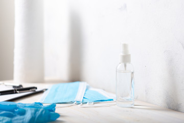 Sanitizer hand protection spray. Medical masks, gloves, paper towel roll and clipboard.