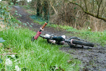 Child's bike found abandoned on muddy pathway wide shot