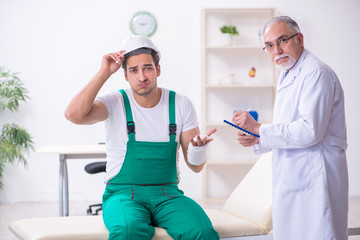 Young male contractor visiting old doctor