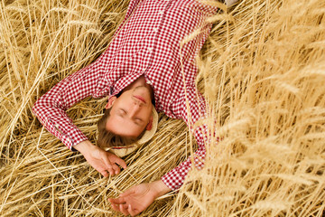 Young handsome happy man lying in wheat field 