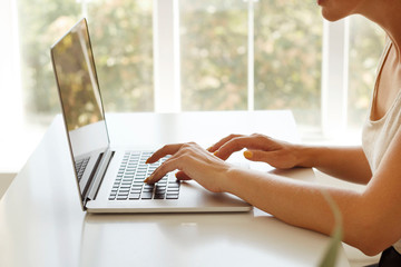 Close up picture of woman’s hands working at laptop. Freelance work concept.