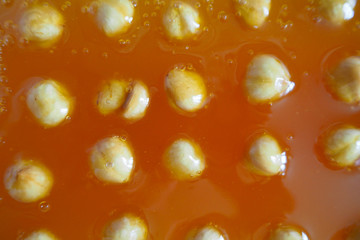 hazelnuts are spread out in an orange Turkish delight to solidify during cooking . oriental sweets . gluten-free . home cooking