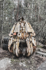 Fototapeta na wymiar Radioactive grasper in Chernobyl Exclusion Zone. Very dangerous machine and radioactive. Famous as the tool to clean after the nuclear disaster.