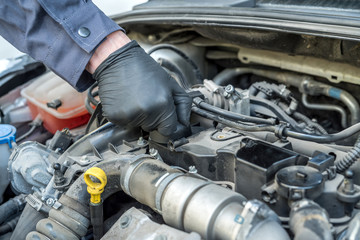 mechanic is opening the oil cap for change of oil from a car engine