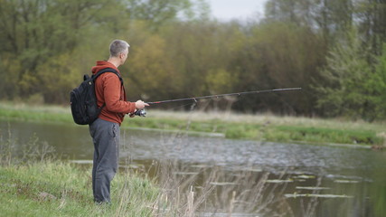Fototapeta premium fishing man in a beautiful place in the meadow, spring