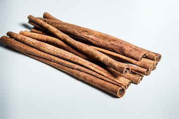 large pile of dry cinnamon sticks served on white table surface