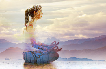 Silhouette of woman doing yoga in lotus position over lake landscape. Concept of connection with...