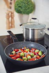 Vegetables frying in pan on stove. Cooking at home