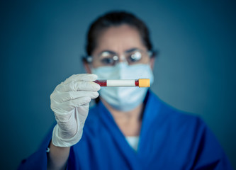 Scientist testing coronavirus positive blood sample researching for COVID-19 antibodies and vaccine