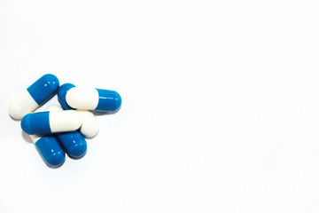 Blue white pills capsul on white background. Top view.