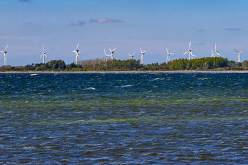 Oland, Sweden Wind turbines in a yellow field and the Baltic Sea.