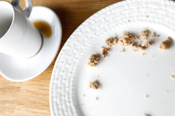 Place setting with mug and plate with crumbs left over from snack or dessert.