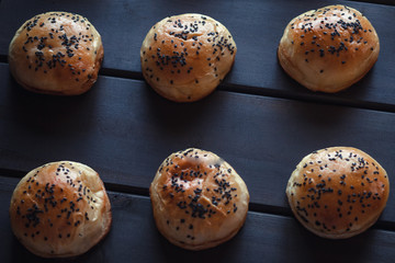 Freshly baked black sesame hamburger bun on wooden background