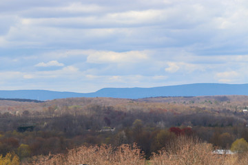 Obraz premium fields and blue mountains in the distance with white puffy clouds in the sky