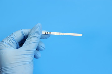 Positive ovulation test in the hand of a doctor, a nurse in a glove