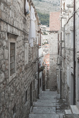 Fototapeta na wymiar Small street in Dubrovnik in Croatia. Summertime, empty street with stairs. Early morning. Very atmospheric photo.