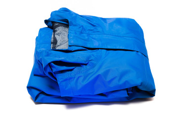 Folded blue zipper windbreaker jacket, rain proof and waterproof hiking Gore-Tex jacket hoodie. Track jacket sport nylon full zip isolated on white. Folded clothes. Outer layer garment for travel.