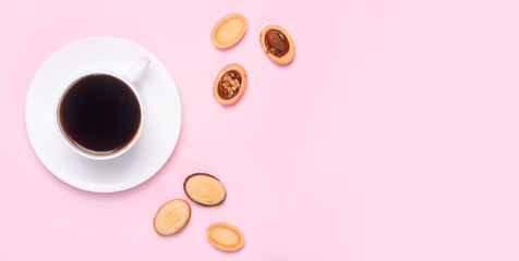 Homemade Russian nuts with condensed milk on a light pink background, wafer napkin. Cut nuts with condensed milk. Bitten goodies for coffee.